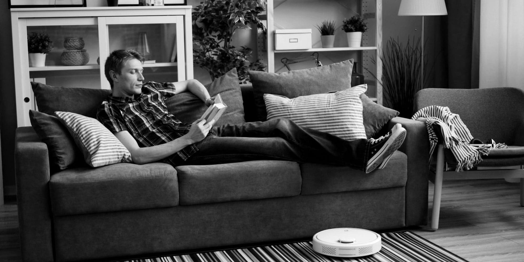 a man laying on a couch reading a book